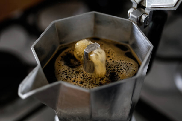 Bubbling espresso coffee in a stovetop moka express. - Zdjęcie, obraz