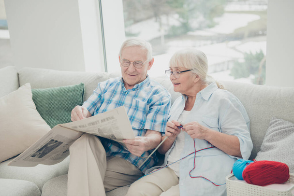 Photo of two pretty aged people pair spending time together reader fresh article sitting sofa comfortable bright flat indoors - Photo, image