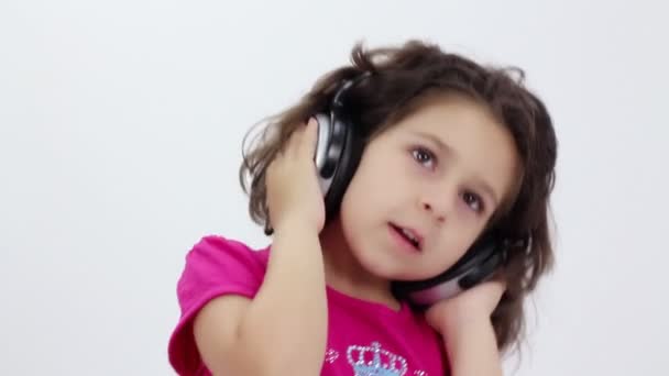 Little girl listening to music with headphones - Filmagem, Vídeo