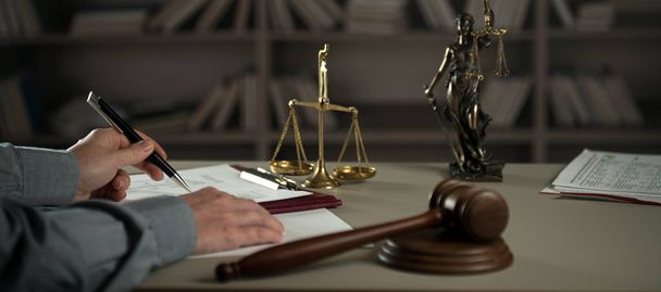 Δικαστής που εργάζεται στο τραπέζι με σύμβολα δικαίου και δικαιοσύνης - Φωτογραφία, εικόνα