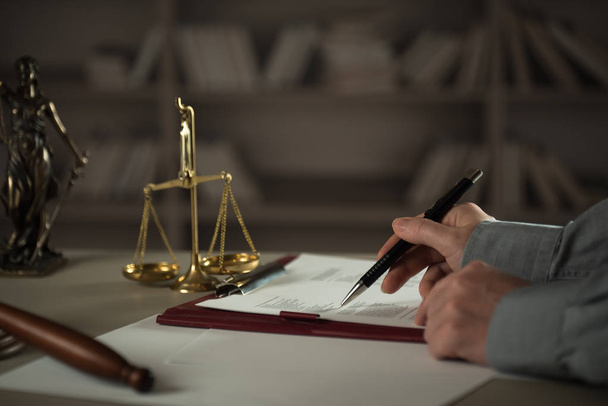 Az asztalnál dolgozó bíró a jog és az igazságszolgáltatás szimbólumaival - Fotó, kép