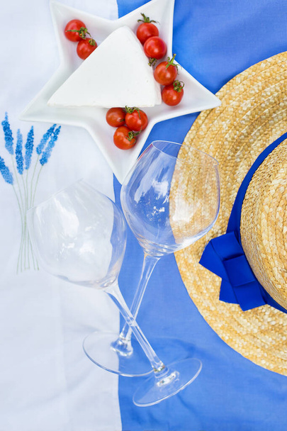 Käse, Tomaten, Gläser auf blauem Tischtuch mit Stickerei - Foto, Bild