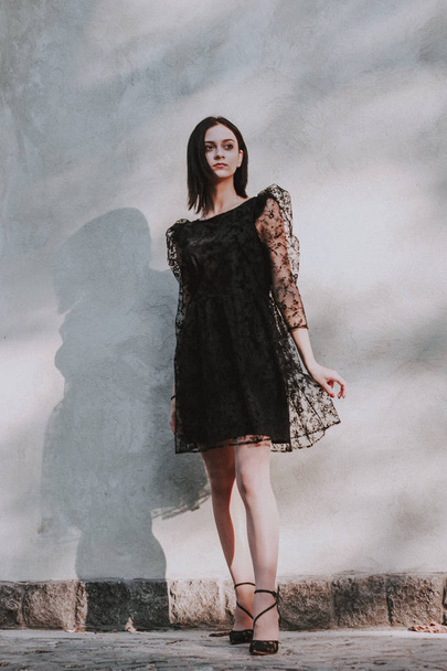 Black-haired girl. Black lace dress. Model shooting. Fashion and - Foto, imagen