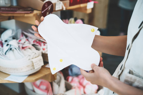 Woman with cloth menstrual pads in zero waste shop. - Фото, зображення