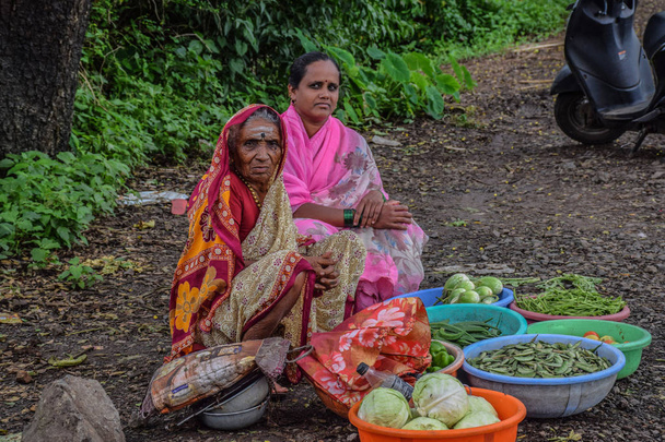 Изображение матери и дочери, продающих свои товары на рынке
 - Фото, изображение