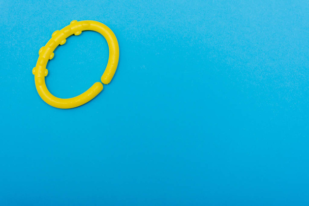 Um clipe de bebê círculo amarelo brilhante em aqua brilhante ou fundo azul
 - Foto, Imagem
