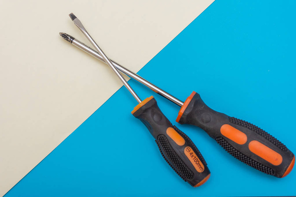 Home improvement: two screwdrivers (philips and slotted) on a blue and white flat lay background with copy space. - Photo, image