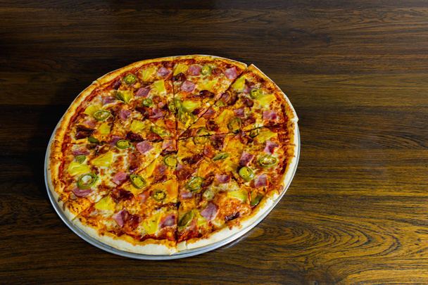 Amerikai pizza ananásszal és sonkával a fa asztalon. - Fotó, kép