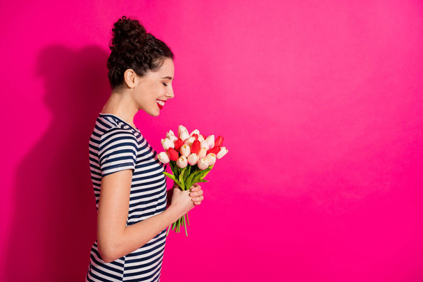 Profile side photo of positive cheerful girl get green tulips for 8-march 14-february smell fresh aroma feel peaceful enjoy spring event wear trendy style outfit isolated bright color background - Foto, Imagen