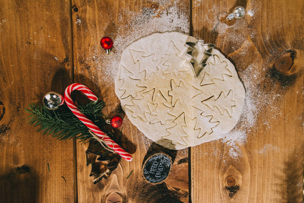 Kerst koekjes bereiden op een houten ondergrond, plat leggen, top  - Foto, afbeelding