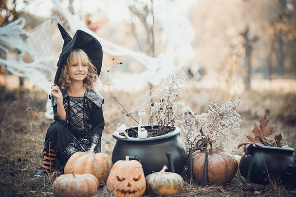 schöne Mädchen Hexe. kleines Mädchen in welchem Kostüm feiern Halloween im Freien und Spaß haben. Kinder tricksen oder behandeln - Foto, Bild