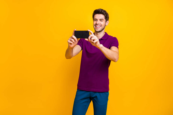 Portrait of his he nice attractive lovely cheerful cheery glad guy taking making selfie having fun isolated over bright vivid shine vibrant yellow color background - Foto, Imagem