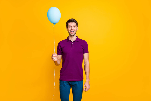 Portrait of his he nice attractive cheerful cheery glad guy holding in hand air ball having fun isolated over bright vivid shine vibrant yellow color background - Foto, afbeelding