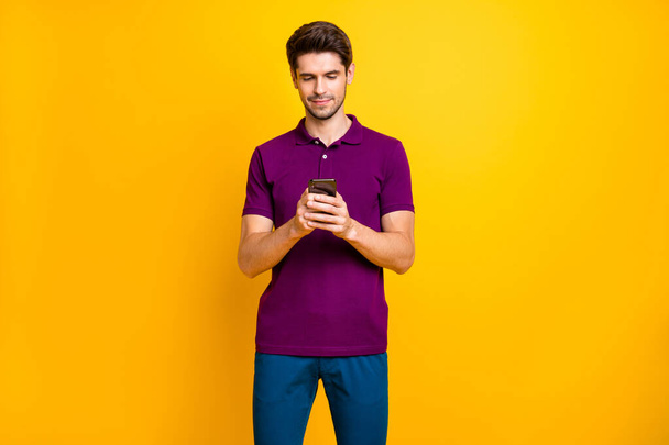 Portrait of his he nice attractive content focused concentrated guy wearing violet shirt browsing web date service isolated on bright vivid shine vibrant yellow color background - Photo, Image
