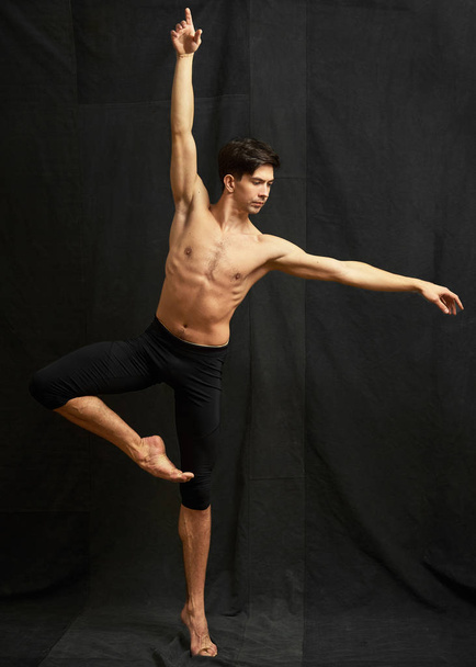 Mladý baletní tanečník v pohybu na černém pozadí tkaniny - Fotografie, Obrázek