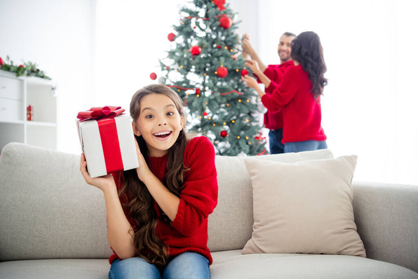 Portrait of nice attractive lovely delighted positive cheerful cheery glad family celebrating enjoying leisure celebratory christmastime sitting on divan in decorated light white interior living-room - 写真・画像