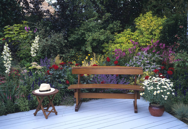 Seat, decking with colourful border at a country garden - Photo, Image