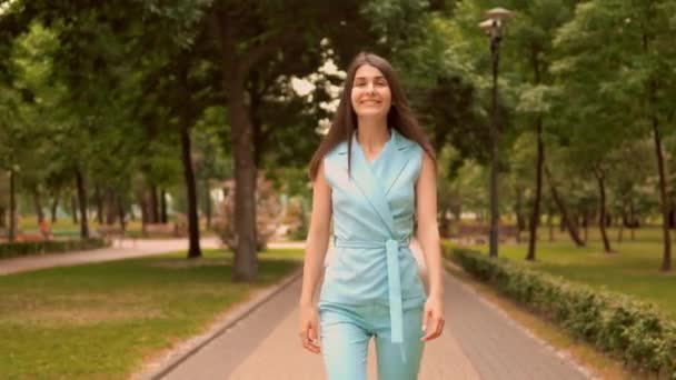 mujer de negocios delgada en azul elegante traje camina en la zona peatonal tienen cámara de aspecto divertido
 - Imágenes, Vídeo