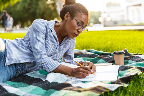 Image of brunette african american woman studying with books in  - Foto, Imagem