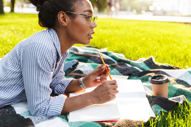 Image of concentrated african american woman studying with books - Photo, Image
