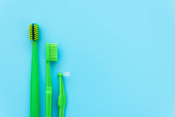 Original, orthodontic, angle interdental tooth brushes on blue background. Healthy lifestyle. Flat lay. Top view - 写真・画像