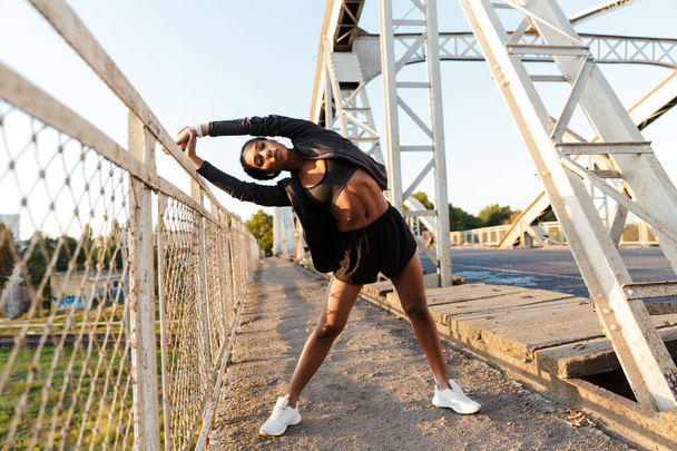 Photo of african american woman using earpods and doing exercises - 写真・画像