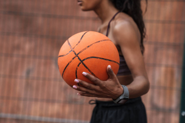 Attractive young african sportswoman playing basketball - Foto, Imagen