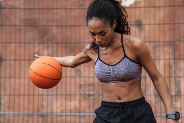 Attractive young african sportswoman playing basketball - Foto, Imagem