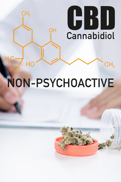 selective focus of container with medical cannabis near doctor writing prescription and non-psychoactive cbd illustration - Foto, afbeelding