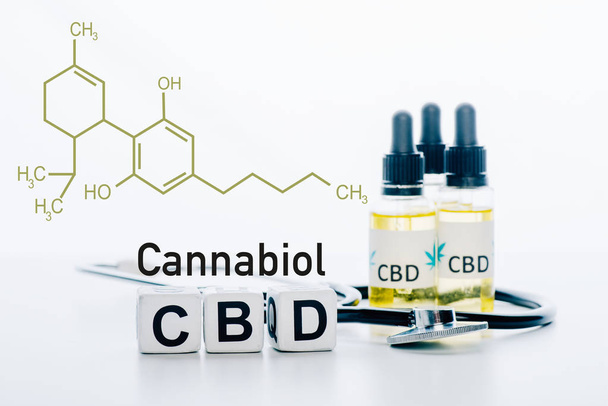 cubes with cbd lettering near oil and stethoscope isolated on white with cbd molecule illustration - 写真・画像