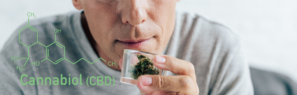 przycięty widok człowieka w t-shirt trzymając medyczną marihuanę w szklanym pojemniku, panoramiczne ujęcie z cbd cząsteczki ilustracji - Zdjęcie, obraz