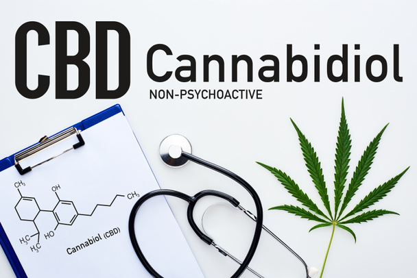 top view of medical cannabis leaf, clipboard with cbd molecule illustration near stethoscope on white background with cannabidiol lettering - 写真・画像
