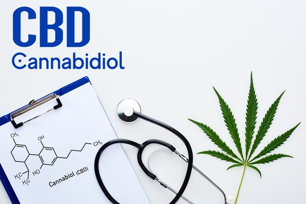 vista superior de la hoja de cannabis medicinal, portapapeles con ilustración de moléculas de cbd cerca del estetoscopio sobre fondo blanco con letras de cannabidiol
 - Foto, imagen