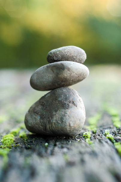 Closeup of stone balance of pebbles on wooden table in outdoor  - 写真・画像