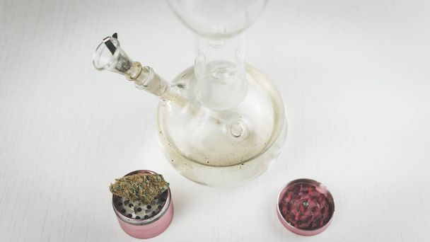 Nahaufnahme von Bong und Mühle mit medizinischen Marihuana-Knospen auf der  - Foto, Bild