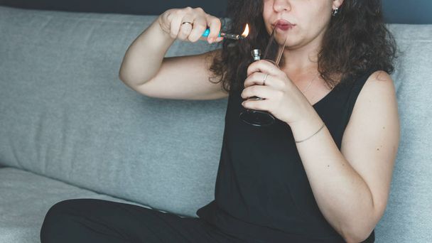 Nuori henkilö tupakoi lääkemarihuanaa bongin kanssa sisätiloissa. T artikla
 - Valokuva, kuva