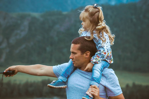 isä ja tytär vuorten taustalla
 - Valokuva, kuva