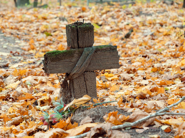 altes Holzkreuz auf einem Grab auf einem Friedhof im Herbst - Foto, Bild