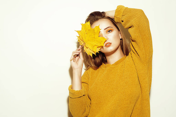 elegantní dívka v podzimním svetru, módní phono s podzimní žlutou le - Fotografie, Obrázek