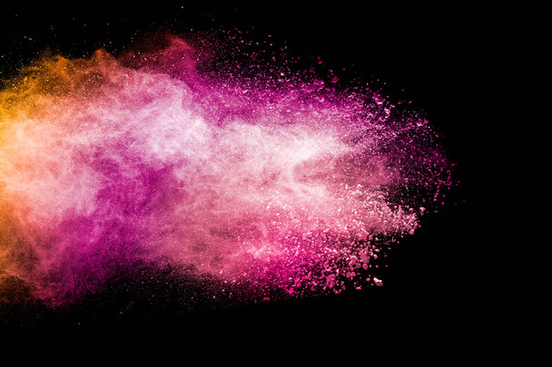 Αφηρημένη ροζ και πορτοκαλί σκόνη έκρηξη σε μαύρο φόντο. Παγωμένη κίνηση ροζ πορτοκαλί σκόνη πιτσιλίσματος. - Φωτογραφία, εικόνα