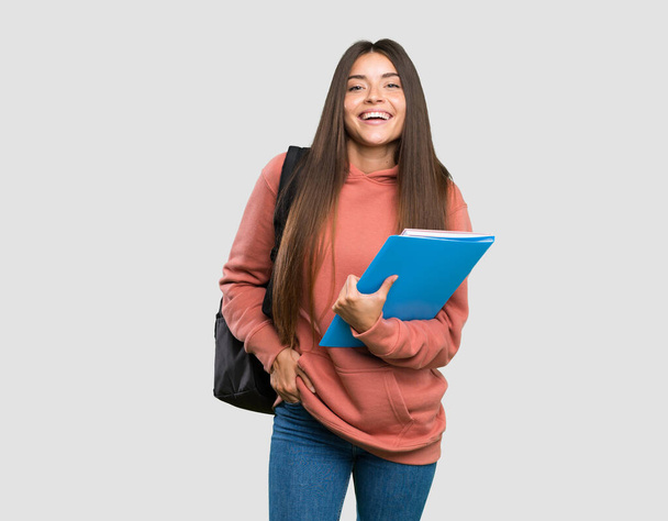 Giovane studentessa in possesso di quaderni ridere su isolato sfondo grigio
 - Foto, immagini