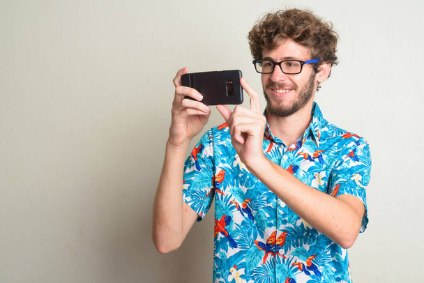 Feliz joven barbudo turista tomando fotos con el teléfono
 - Foto, Imagen