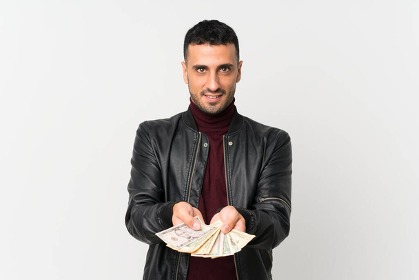 Young man over isolated white background taking a lot of money - Photo, Image