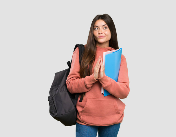 Fiatal diák nő kezében notebook cselszövés valami felett elszigetelt szürke háttér - Fotó, kép