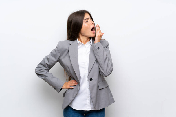 Young business woman over isolated white background yawning and covering wide open mouth with hand - Valokuva, kuva