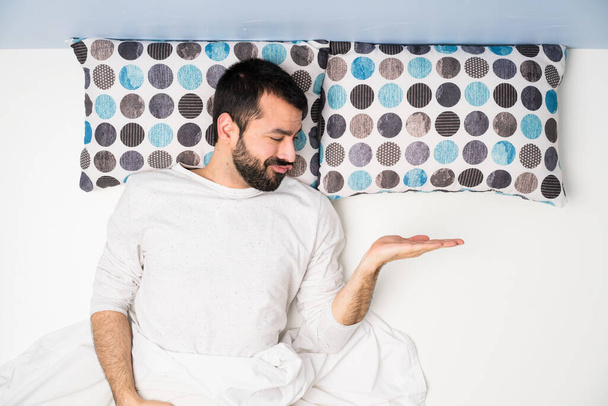 Mann im Bett in der Draufsicht mit Zweifeln - Foto, Bild