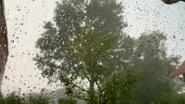 Una fuerte tormenta ruge desde detrás de la ventana mientras gotas de agua golpean la ventana
 - Imágenes, Vídeo
