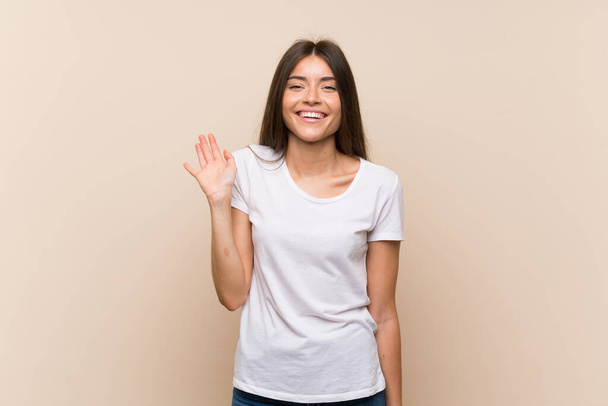 Pretty young girl over isolated background saluting with hand with happy expression - Valokuva, kuva
