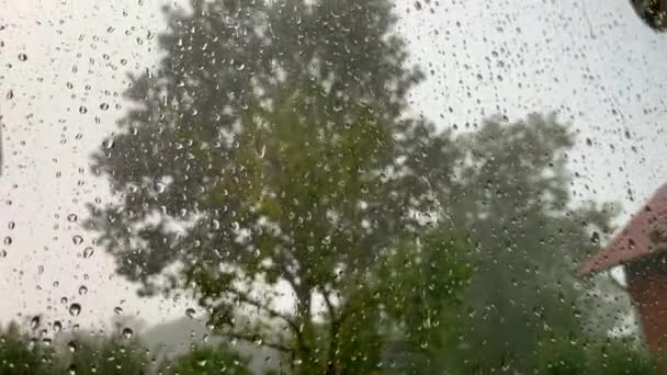 Una fuerte tormenta ruge desde detrás de la ventana mientras gotas de agua golpean la ventana
 - Imágenes, Vídeo