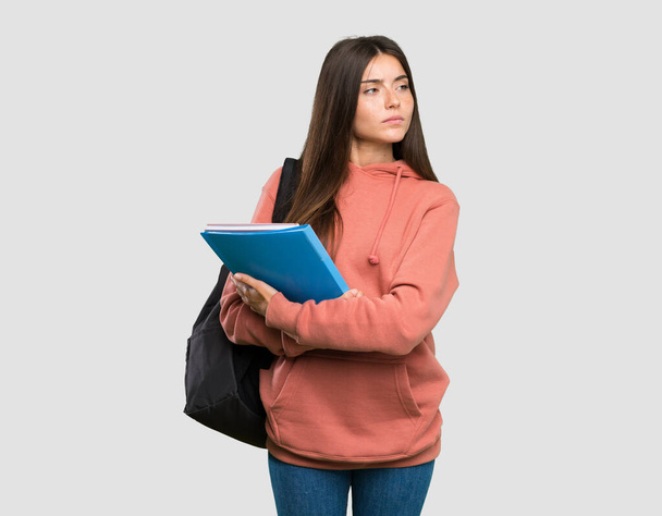 Young student woman holding notebooks portrait over isolated grey background - Foto, Bild